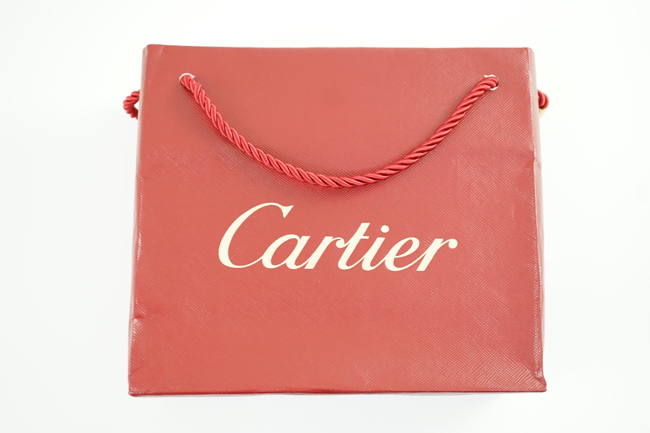 A Cartier red leather notebook, boxed, with bag, papers and certificate